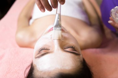 Spa konsepti. Güzellik salonunda besin maskesi takan genç bir kadın.