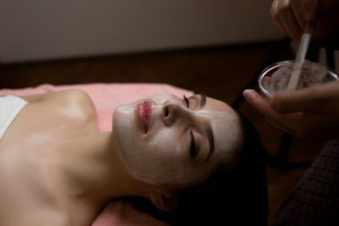 Spa Kadını Yüz Temizleme Maskesi uyguluyor. Güzellik Tedavileri