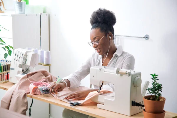 Afrikansk sömmerska som arbetar med tyg vidtar åtgärder — Stockfoto