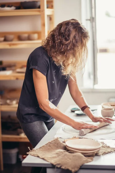 Çömlek atölyesinde merdaneli kadın çömlek kalıbı.