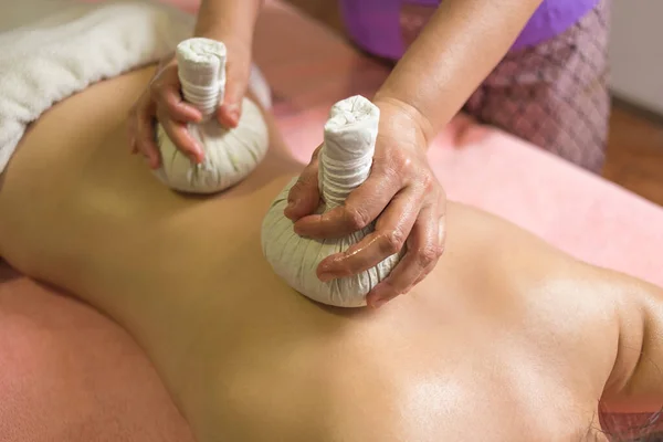 Massagem de bola tailandesa. Mulher no dia SPA recebendo massagem de ervas tailandesas. — Fotografia de Stock