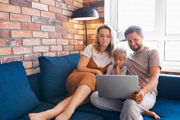 Família caucasiana sentar usando laptop no sofá em casa — Fotografia de Stock