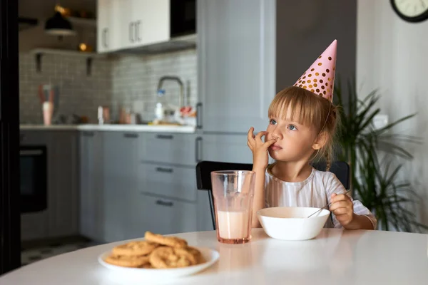 Docela rozkošná dívka sedí v kuchyni sama — Stock fotografie