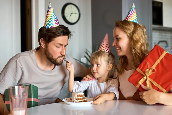 예쁜 여자 애가 부모님과 생일 케이크를 먹고 — 스톡 사진