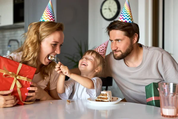 Mignonne petite fille enfant traite les parents avec gâteau d'anniversaire — Photo