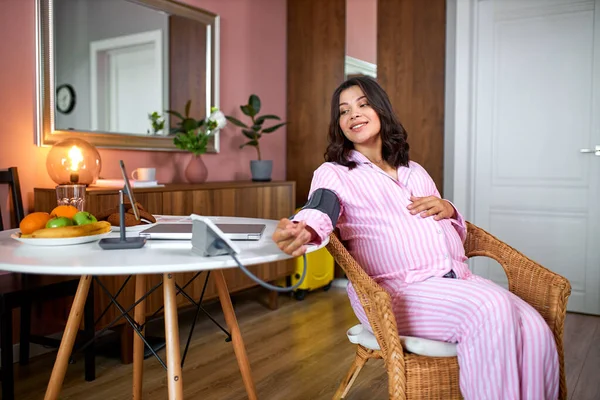 Femeie gravidă fericită care măsoară tensiunea arterială acasă — Fotografie, imagine de stoc