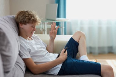 Genç beyaz çocuk arkadaşlarıyla internette konuşuyor.