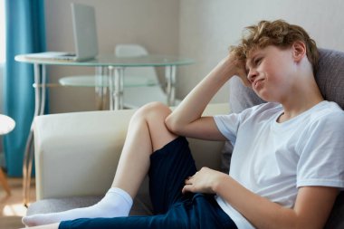 Uykulu kıvırcık saçlı çocuk evde rahatla.