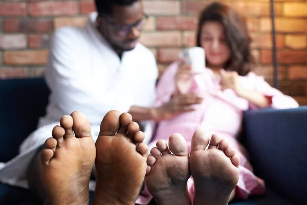 Primer plano foto de los pies, pareja interracial tienen descanso en casa — Foto de Stock