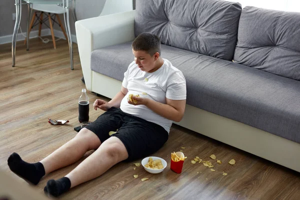 Gordo sobrepeso adolescente chico tiene mala nutrición, comer alimentos poco saludables —  Fotos de Stock