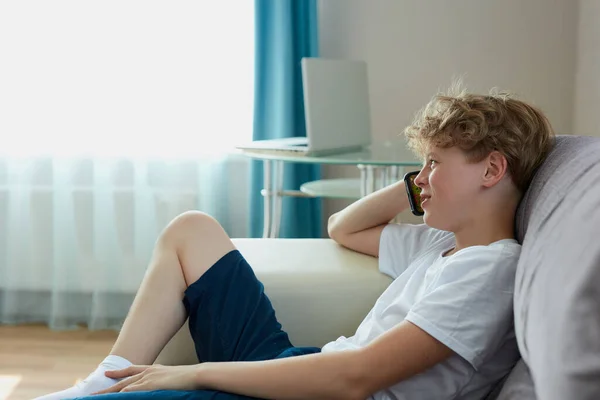 Child boy sits talking on phone with mom — Stock Photo, Image