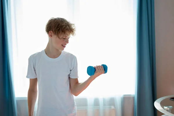 Przystojny szczęśliwy nastolatek chłopiec zrobić sport traning w domu — Zdjęcie stockowe