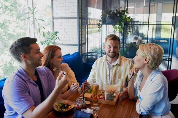 Hermoso caucásico hombres y mujeres celebrar reunión amistosa en la cafetería — Foto de Stock