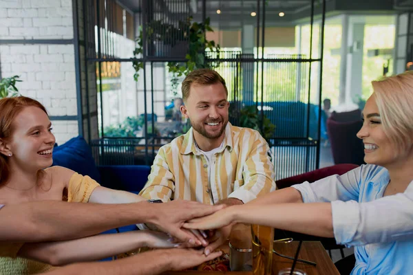 Collègues unissant les mains dans le restaurant — Photo