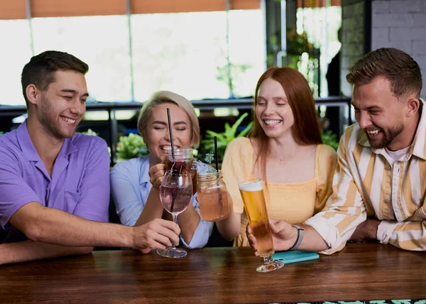 Grupo de amigos tintinean vasos con bebidas en la cafetería — Foto de Stock