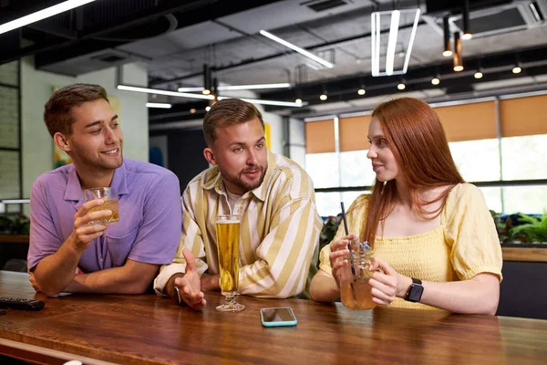 Retrato de tres jóvenes divirtiéndose en el bar — Foto de Stock