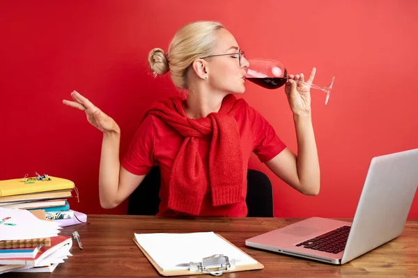 Güzel bir bayan işini seviyor ve şarap içiyor.