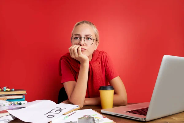 사무실 책상에 노트북과 서류와 함께 앉아 있는 자신감 있는 금발 여성의 사진 — 스톡 사진