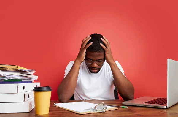 Υπερφορτωμένος δυστυχισμένος και απογοητευμένος νεαρός Αφρικανός με άγχος κάθεται στο γραφείο του γραφείου — Φωτογραφία Αρχείου