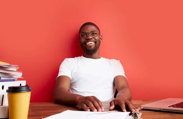 Pozitif genç siyah adam ofis masasında oturuyor. — Stok fotoğraf