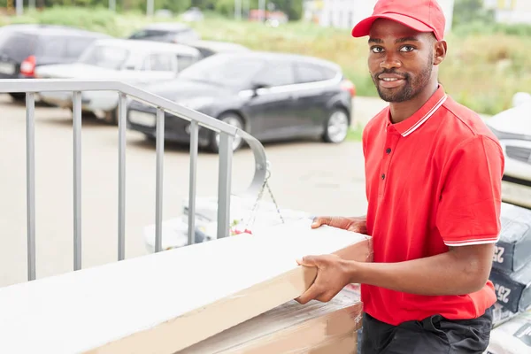 Молодой африканский мужчина работает в компании доставки, пришел к клиентам — стоковое фото