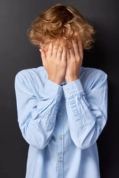 Korkmuş çocuk elleriyle yüzünü kapattı.