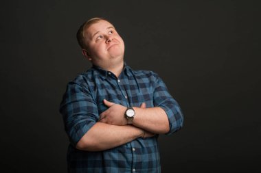 Şişman beyaz adam düşünüyor ve boşluğa bakıyor.