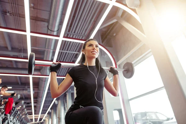 Gadis melakukan lunges dengan barbel di gym modern — Stok Foto
