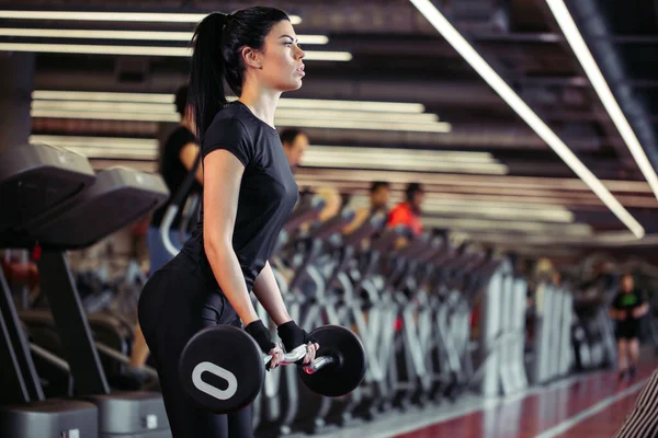 Fitness, zblizka mladé ženy vyzvednout pro biceps v tělocvičně — Stock fotografie