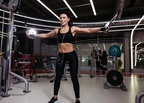 Femme en forme exécuter l'exercice avec la machine d'exercice Cable Crossover dans la salle de gym — Photo