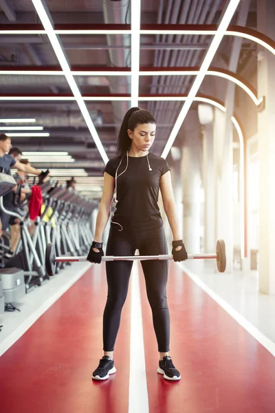 Kadın spor salonunda ağırlık kaldırma antrenmanına hazırlanıyor. — Stok fotoğraf