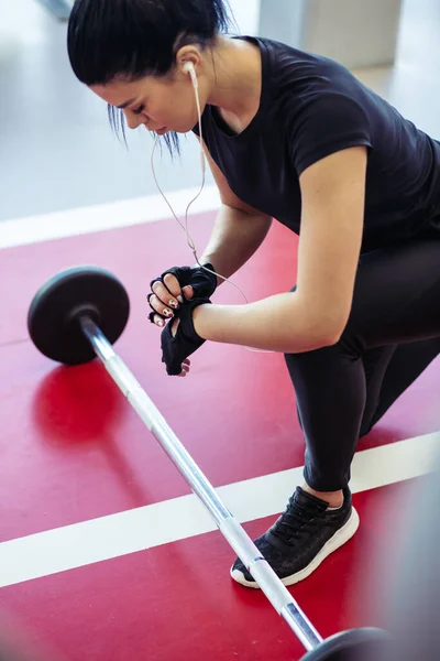 Mujer preparándose para su entrenamiento de levantamiento de pesas con pequeña barra — Foto de Stock