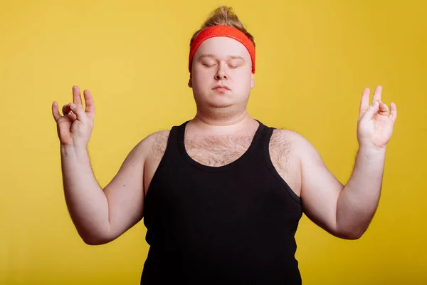 Gros homme relaxant avec méditation sur fond jaune — Photo