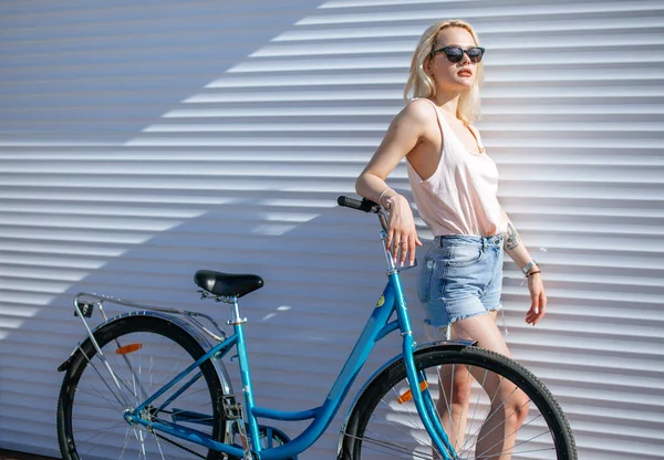 Femme aux cheveux blonds près du vélo isolé sur fond blanc. — Photo