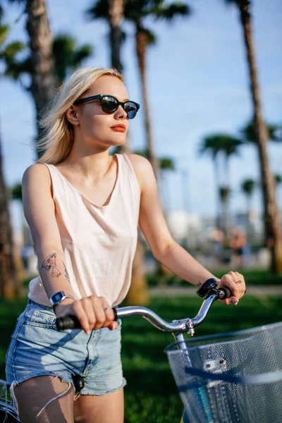 즐거운 금발의 여자가 공원에서 자전거를 타고 여름 오후에 재미있게 노는 모습 — 스톡 사진