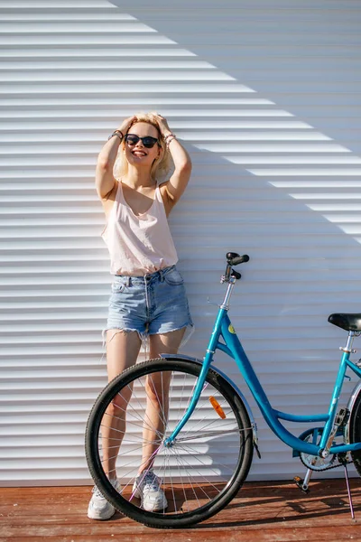 Menina bonita com cabelo loiro com bicicleta isolada no fundo branco. — Fotografia de Stock