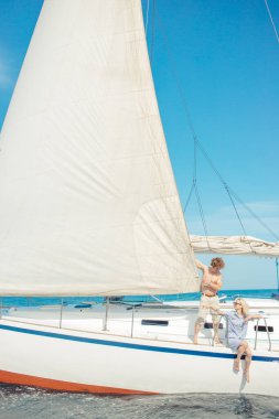 Güneşli bir günde sakin denizde beyaz yelkenli..