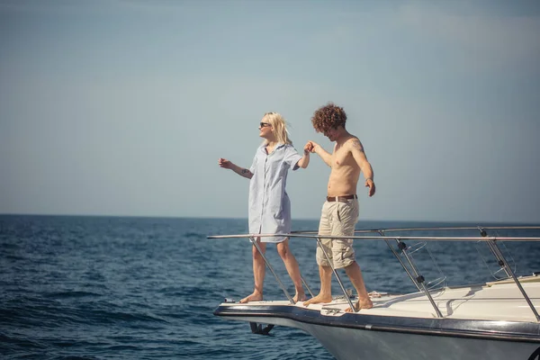 Junges romantisches Paar sitzt am Bug des Bootes und fühlt sich überglücklich und entspannt — Stockfoto