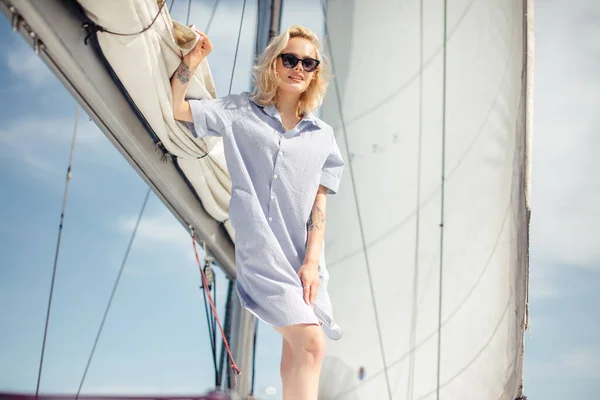Mulher caucasiana jovem desfrutando de viagem no convés de iate navegando no mar. — Fotografia de Stock