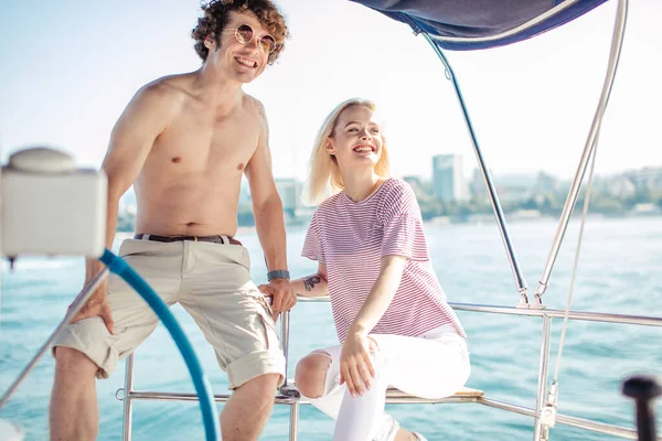 Young happy couple navigating on a yacht in caribbean sea