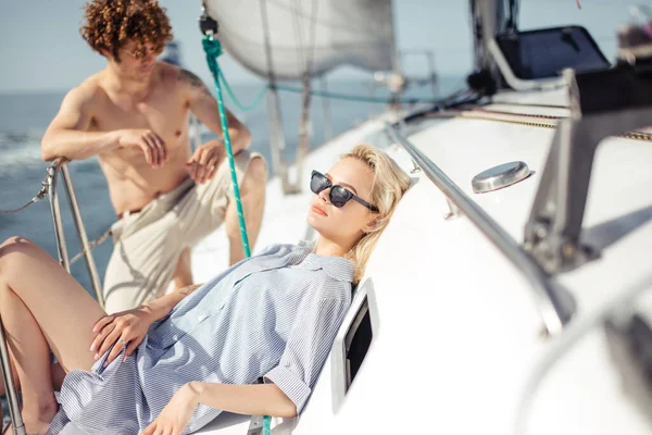 Loving couple lying on yacht at sea. Luxury vacation on seaboat. — Stock Photo, Image
