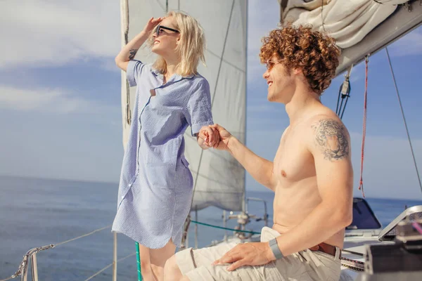 Mann mit Freundin am Ruder einer Jacht und Blick in die Ferne — Stockfoto