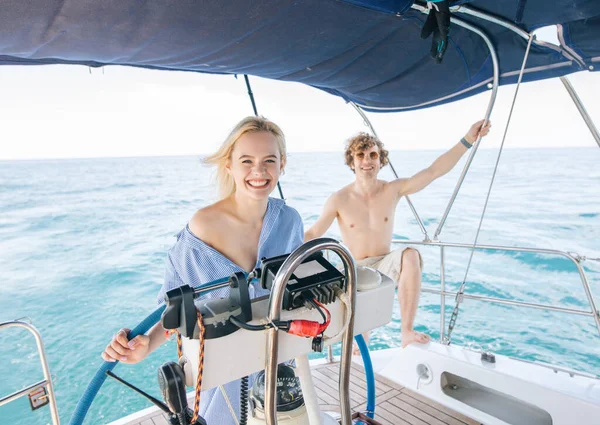 Feliz joven pareja enamorada sonriendo y disfrutando de un viaje en yate por el mar. — Foto de Stock