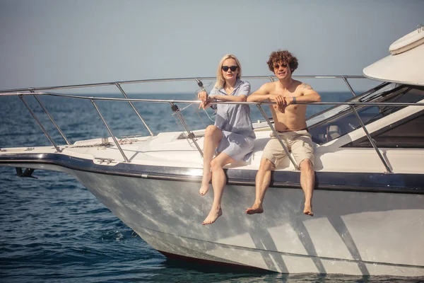 Jovem casal romântico sentado no arco do barco, sentindo-se muito feliz e relaxado — Fotografia de Stock