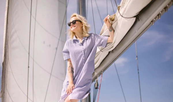 바다의 바다 주제로 하얀 요트를 타고 있는 여성. 금발에 푸른 옷. — 스톡 사진