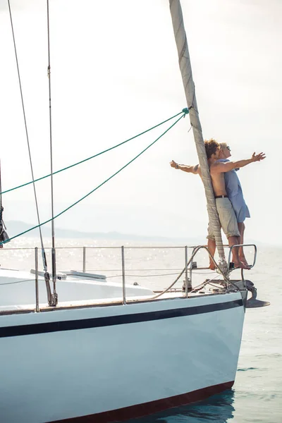 Menschen, die auf Yachtgeländern dicht beieinander stehen wie Titanic-Posen. — Stockfoto