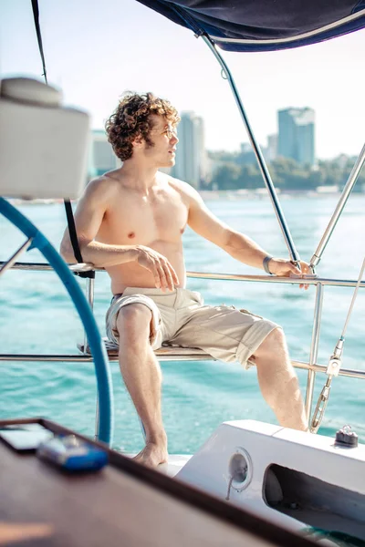 Man with frizzy hair relaxing happily on the vacation sailboat yacht