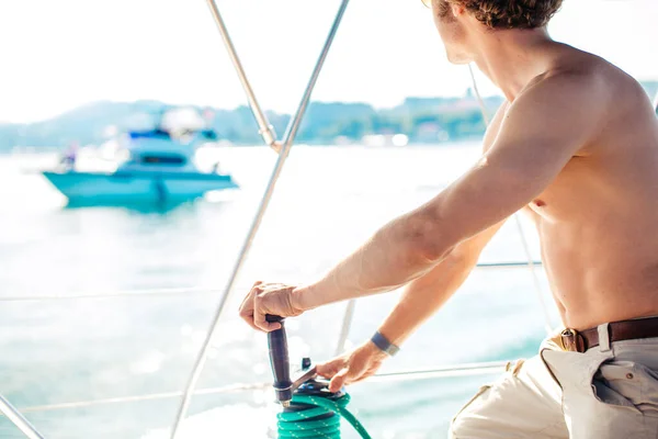 Kapitän Segelboot arbeitet auf dem Boot mit Winde auf einem Segelboot. — Stockfoto