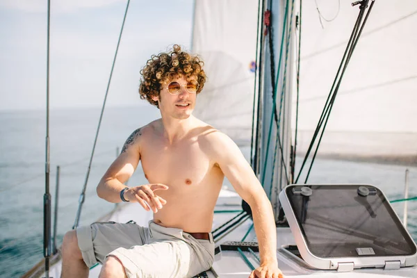 Homem com cabelos crespos relaxando alegremente no iate de férias veleiro — Fotografia de Stock