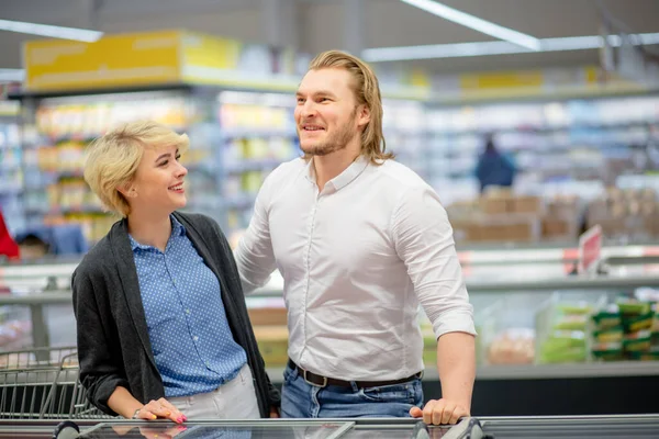 Gelukkig Kaukasisch paar kiezen bevroren voedsel bij supermarkt in winkelcentrum. — Stockfoto